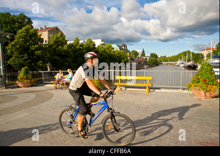 Uomo in bicicletta oltre il ponte Aurasilta Turku Finlandia con la guglia della Cattedrale sullo skyline Foto Stock