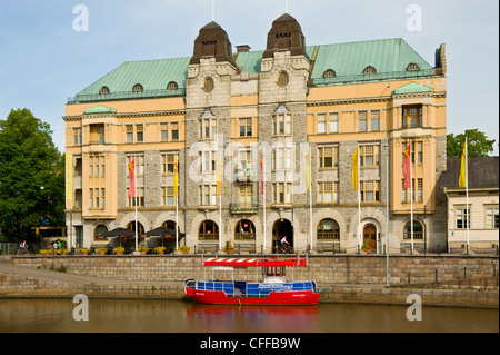 Guardando al di là del fiume Aura (Aurajoki), Turku Finlandia all'Art Nouveau Town Hall. Nella parte anteriore è il piccolo traghetto Pikkuföri Foto Stock