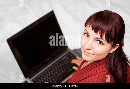 Felice bella giovane donna utilizzando laptop Foto Stock