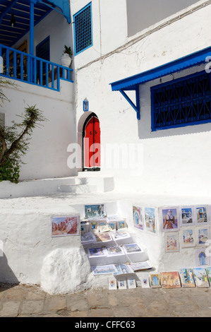 Sidi Bou Said. La Tunisia. Vista dei dipinti di souvenir in vendita presso il pittoresco angolo dipinto di bianco in cima alla scogliera del villaggio di Sidi Bou Foto Stock