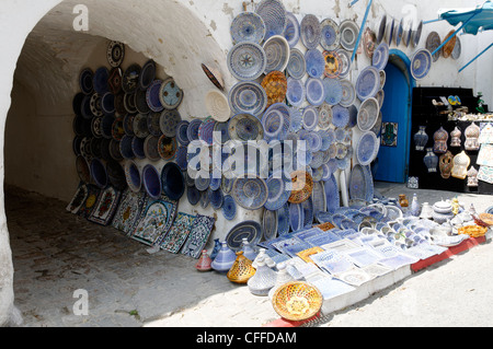 Sidi Bou Said. La Tunisia. Vista di artigianato ornati dipinti dai colori vivaci di piastre in ceramica e negozio di souvenir in vendita in cima alla scogliera Foto Stock