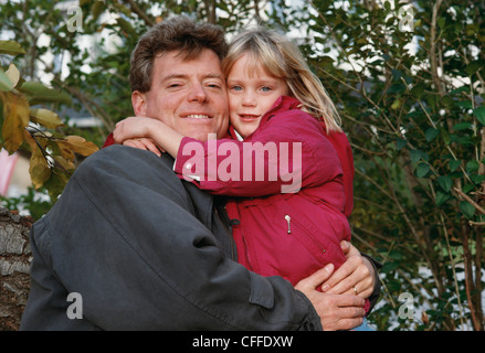 Padre e figlia avvolgente e in posa per la fotocamera Foto Stock