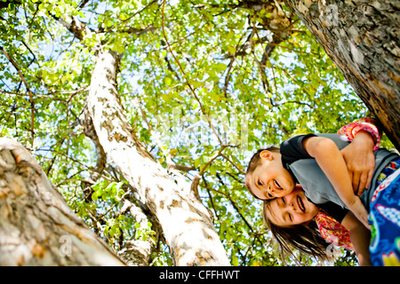Un ragazzo e una ragazza di arrampicarsi su un albero in Garden City, Utah. Foto Stock
