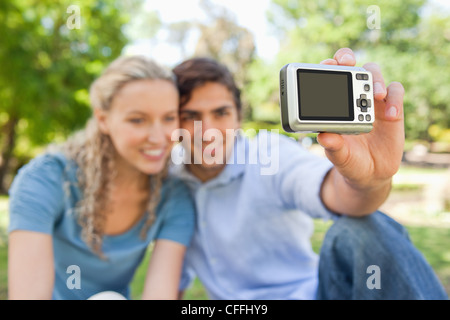 Fotocamera utilizzata per scattare una foto di un sorridente giovane Foto Stock