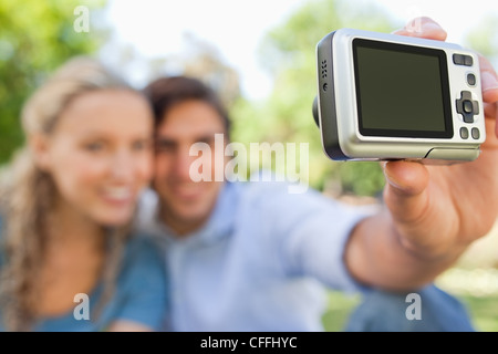 Fotocamera utilizzata per scattare una foto di un sorridente giovane Foto Stock