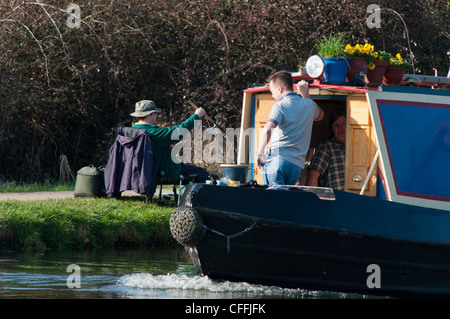 Un uomo pesca come una barca va passato sul fiume Cam. Cambridgeshire, Inghilterra. Foto Stock