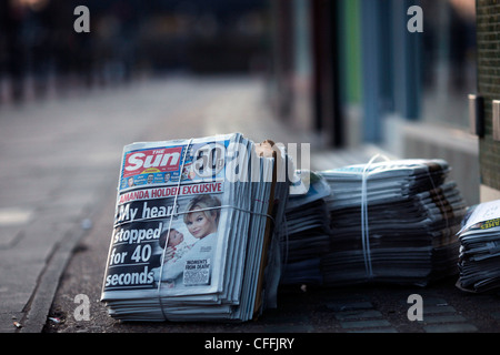 Le prime copie del nuovo giornale il sole di domenica sono visibili lungo il lato altro giornale della domenica nel nord di Londra il 26 febbraio 2012, Foto Stock