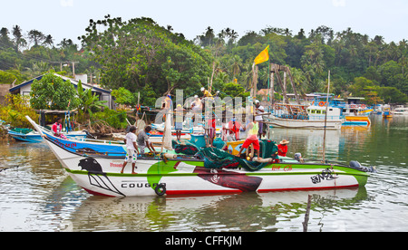 I pescatori si preparano a prendere le loro barche da pesca al di fuori del porto di Mirissa, nel sud dello Sri Lanka, all'inizio di una notte di pesca Foto Stock