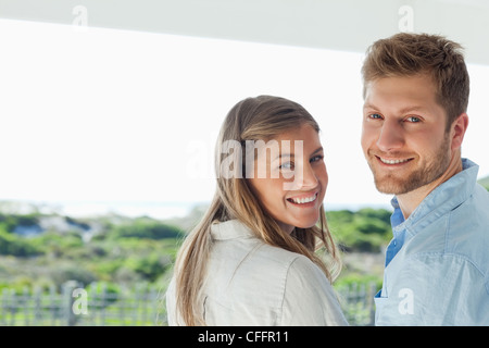 L uomo e la donna sorriso guardare indietro con la videocamera Foto Stock