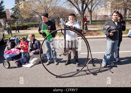 Uomo in piedi accanto ad una alta alta della ruota di bicicletta ruota Foto Stock