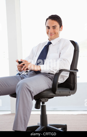Ritratto di un imprenditore sorridente con il suo smartphone Foto Stock