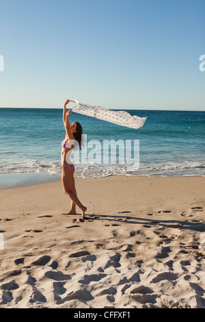 Donna attraente in bikini gioca con un sarong Foto Stock