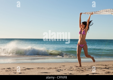 Femmina attraente in bikini gioca con un sarong Foto Stock