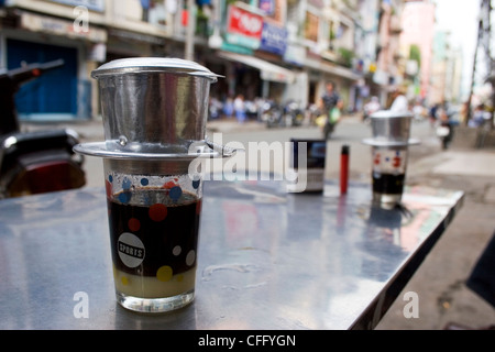 Appena macinato di caffè vietnamita è servita con un inciso in modo univoco cup presso una caffetteria a Saigon (Ho Chi Minh City) Vietnam. Foto Stock