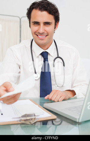 Sorridente medico con la prescrizione in mano Foto Stock