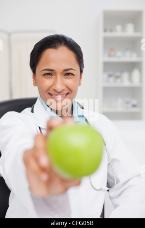 Sorridente curante tenendo una mela verde Foto Stock