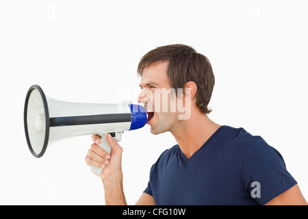 Vista laterale di una furiosa uomo grida in un megafono Foto Stock