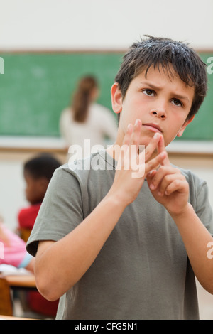 Ragazzo con le dita delle mani per contare Foto Stock