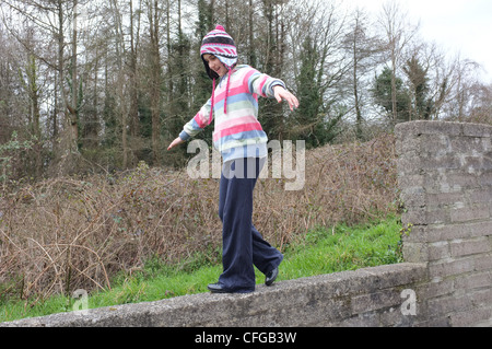 A 9 anni saldi ragazze mentre si camminava su una parete Foto Stock