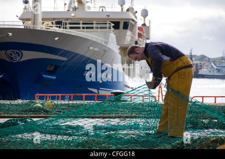 Fisherman riparare reti sulla banchina Foto Stock