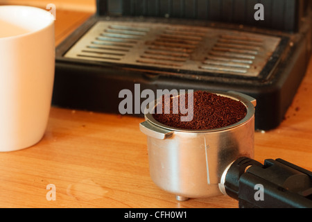 Una macchina espresso portafilter, riempito di caffè macinato pronto per essere 'pestato". Foto Stock