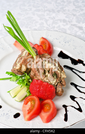 Rotoli di maiale con formaggio e verdure: cipolla, cetrioli e pomodori Foto Stock