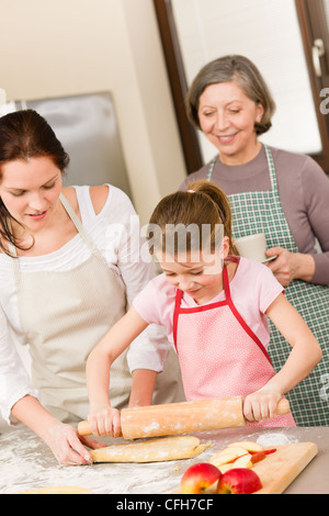 Madre e figlia che rendono Apple insieme a torta nonna ricetta di controllo Foto Stock