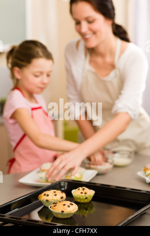 Tortine bambina decorare con un pizzico muffin con la madre Foto Stock