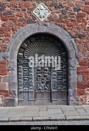 Antica porta di legno in una parete della vecchia pietra arenaria rossa. Una parte della cattedrale vicino a Exeter, Devon, Inghilterra Foto Stock