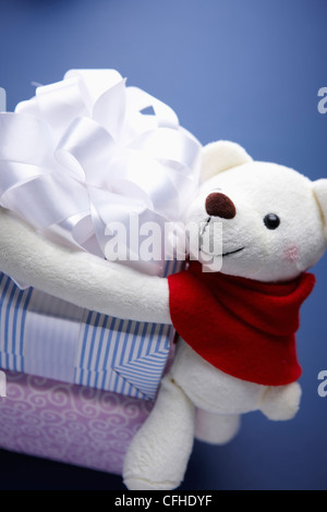 Un orsacchiotto bianco mettendo braccia intorno le confezioni regalo Foto Stock