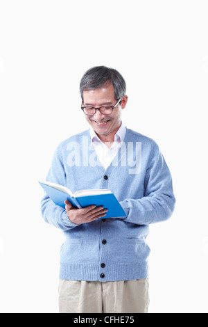 Un uomo anziano la lettura di un libro in bicchieri Foto Stock