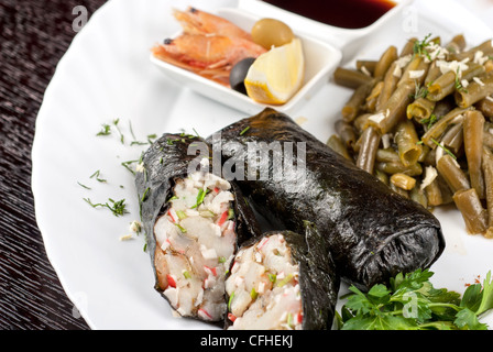 Souffle di filetto di pikeperch, gamberi, carne di granchio, noce di cocco e il porro avvolto a nori guarnita da fagiolini Foto Stock