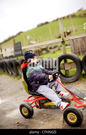 Ragazzo a cavallo di go-kart in una fattoria in Lewes, East Sussex in inverno Foto Stock