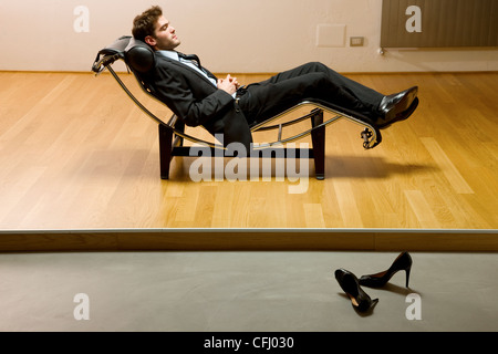 Uomo disteso sulla chaise longue Foto Stock