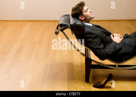 Uomo disteso sulla chaise longue Foto Stock