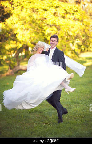 Sposa e lo sposo divertirsi in un parco Foto Stock