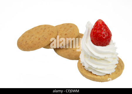 Dessert fantasia con biscotti digestivi,la panna montata e una fragola. Foto Stock