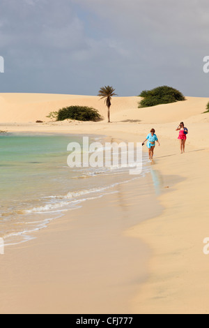 Praia de Chaves, Rabil, Boa Vista, Isole di Capo Verde. Due donne camminando lungo la riva del mare della tranquilla spiaggia di sabbia bianca Foto Stock