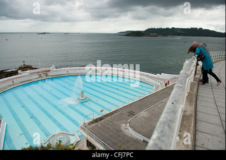 Un paio di sporgersi sopra una ringhiera per vedere il Lido Tinside piscina esterna a Plymouth. Foto Stock