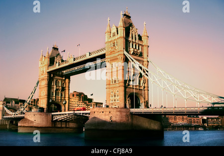 Il Tower Bridge, il famoso ponte di sospensione attraverso il fiume Thames, bagnata dal tardo pomeriggio rosa luce del tramonto, London, England, Regno Unito Foto Stock