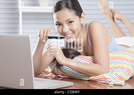 Giovane donna godersi lo shopping online Foto Stock