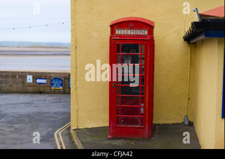 Un tradizionale telefono rosso scatola nel Devon villaggio di Appledore accanto al lungomare. Foto Stock