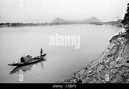 Nave che naviga lungo il Fiume Hooghly (Gange afluent) con quella di Howrah Bridge in primo piano Calcutta, India. Foto Stock