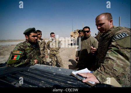 KANDAHAR, Afghanistan - staff Sgt. Dave Hewitt (estrema destra), 966a esplosiva ORDNANCE Disposal volo Operating Location-Bravo partner team leader, debriefins Fakhr Uddin (estrema sinistra) dopo le operazioni di controfirma IED 13 marzo. Gli aeronavi assegnati al team di partnership all'interno di OL-B addestrano, guidano e successivamente convalidano i tecnici EOD dell'esercito nazionale afgano. Foto Stock