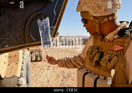 Petty officer di terza classe gregory Jones, un ospedale corpsman con bravo company, combattere il battaglione della logistica 4, primo marine logistics group (avanti), monitor terapia endovenosa durante una interruzione di alimentazione offload di operazioni a inoltrare una base operativa in Pennsylvania il 5 marzo. jones somministrati iv di un marine che erano divenuti disidratato durante il combattimento pattuglia di logistica. Foto Stock