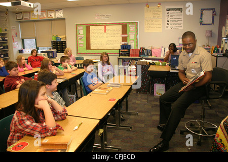 Yeoman Seaman Teylor Tottress, dal Navy Expeditionary Logistics Support Group, Naval Weapons Station Yorktown-Cheatham Annex, legge agli studenti della DJ Montague Elementary School come parte di Read Across America, il compleanno dell'autore per bambini Dr. Suess. I marinai NAVESLG hanno mentito gli studenti della scuola dal 2009. Foto Stock