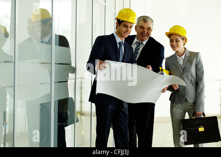 Tre architetti in piedi in ufficio e i lavori di pianificazione Foto Stock