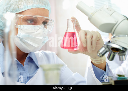 Ritratto di una farmacia azienda un tubo con liquido Foto Stock