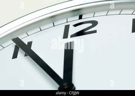 Foto di un orologio che mostra cinque minuti a mezzogiorno Foto Stock