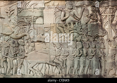 Scultura in pietra raffigurante scene da un corteo militare dell'esercito di Jayavarman VII, tempio Bayon, Angkor Thom, Cambogia Foto Stock